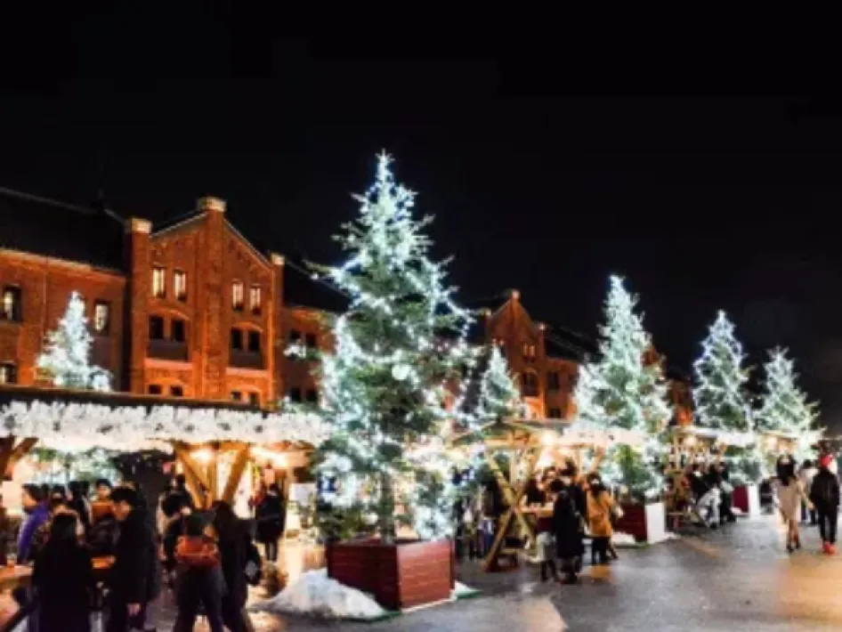 Verlichte kerstbomen en kraampjes op de Kerstmarkt PSW op Genegenterhof in de avond