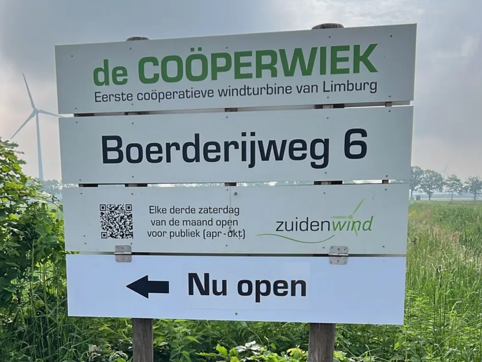 Informatiebord van windturbine De Coöperwiek aan de Boerderijweg in Neer, met windmolens op de achtergrond.