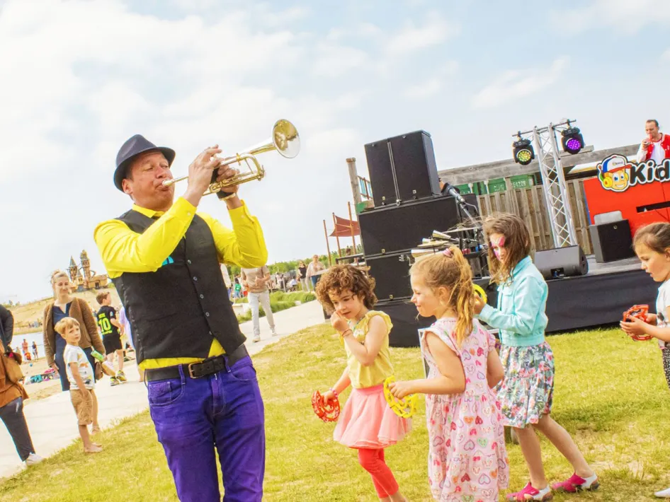 Kinderen dansen bij de muzikant