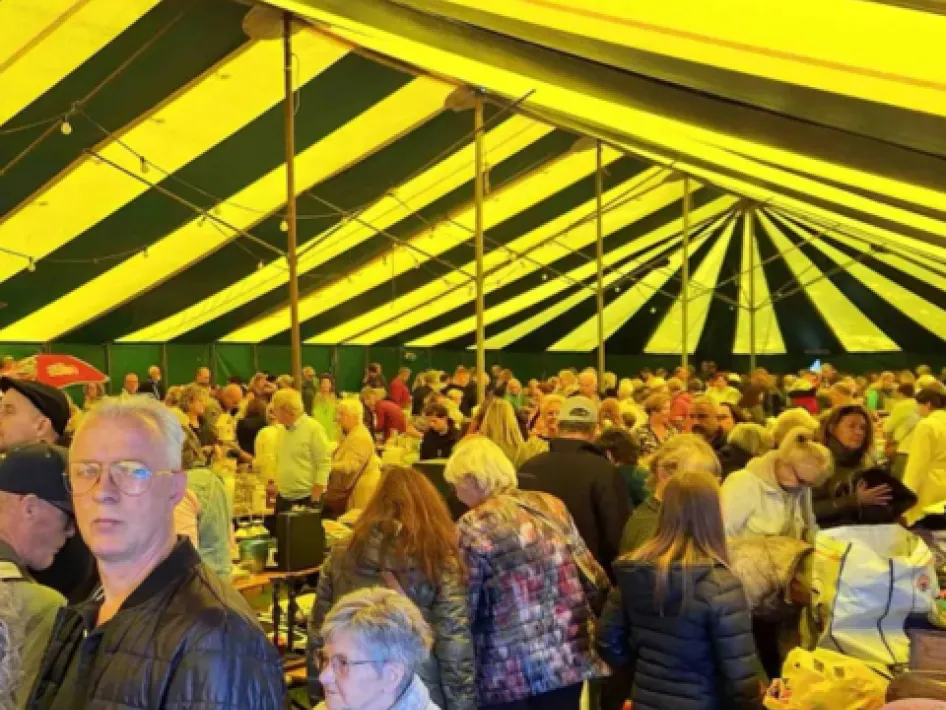 Bezoekers snuffelen langs kramen met tweedehands spullen op de vlooienmarkt Jo Gerrishal Roermond.