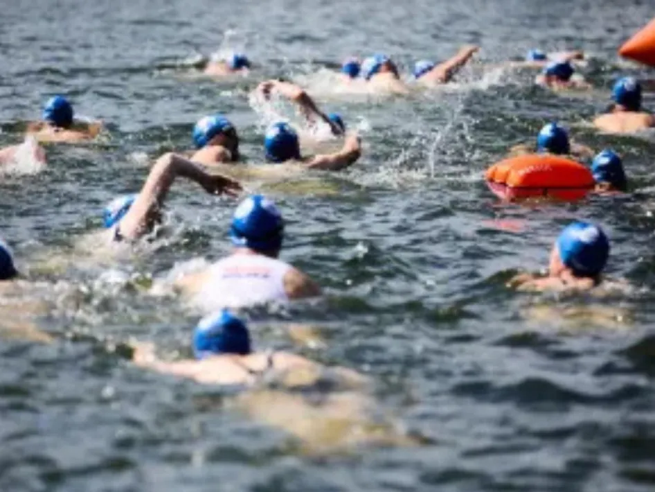 Deelnemers zwemmen samen in open water tijdens Zwemmen tegen kanker Weert om geld op te halen voor kankeronderzoek.
