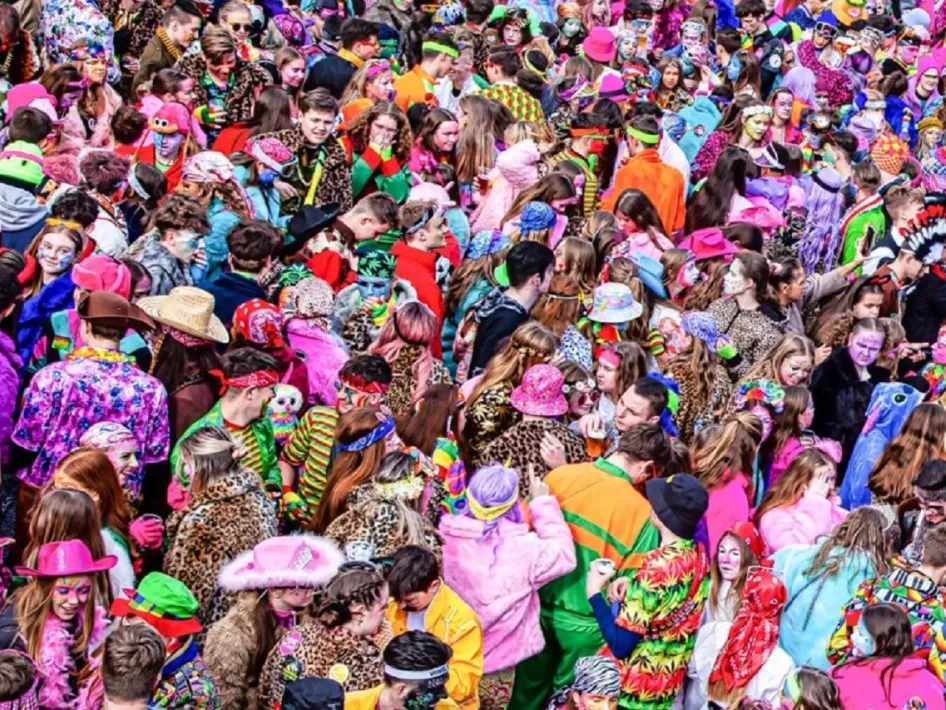 Feestende menigte tijdens Oolderfestasie in Herten, gekleed in kleurrijke carnavalskostuums.