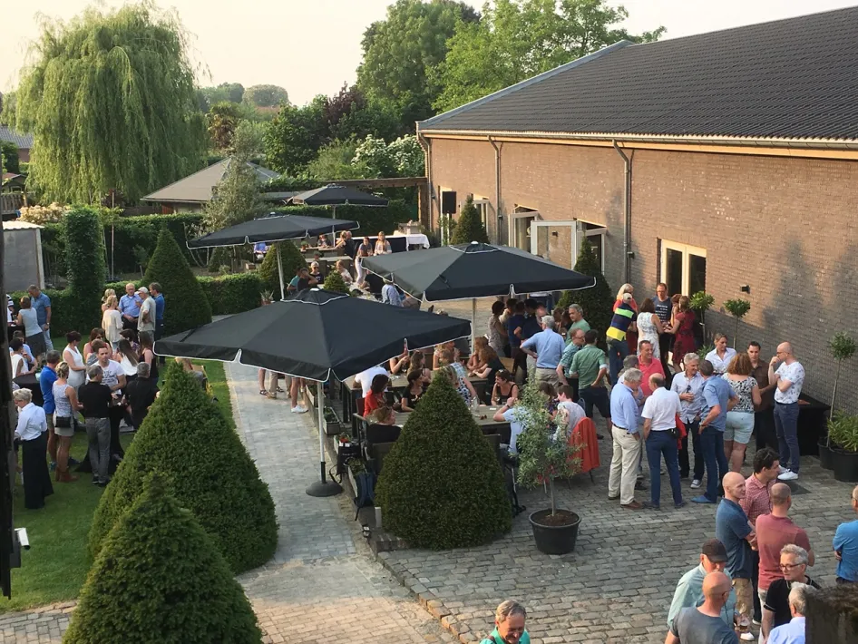 Terras van Oolderhof met gasten tijdens een borrel of netwerkbijeenkomst in een groene omgeving.