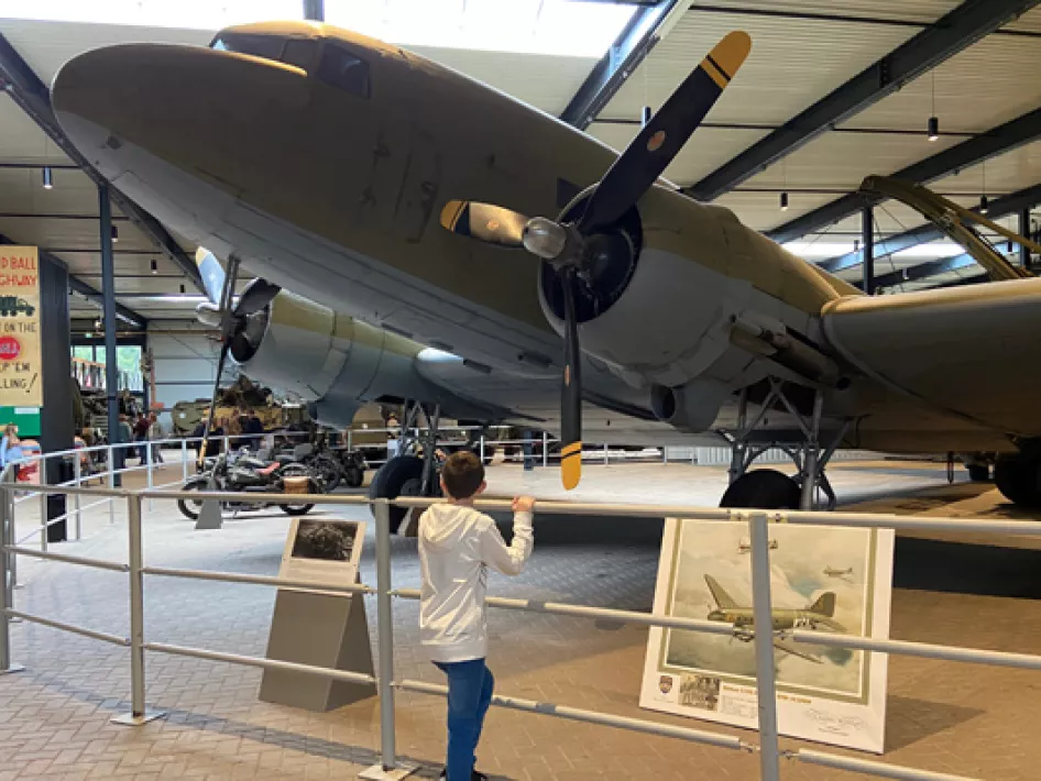 Jongen kijkt naar een Lancaster bommenwerper die tentoongesteld staat in het Oorlogsmuseum Overloon