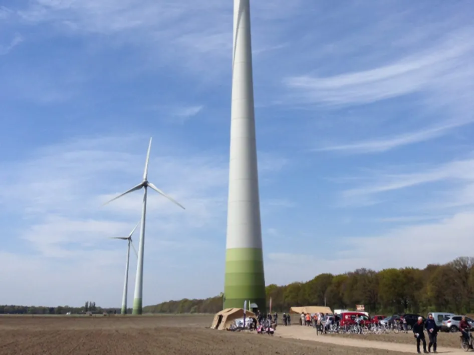 Bezoekers bij de Windturbine Cooperwieck in Neer tijdens een open dag, met imposante windmolens op de achtergrond.