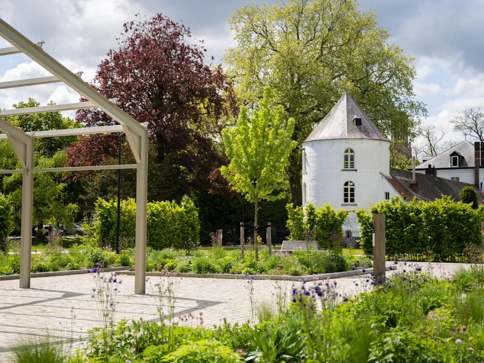 Kasteelpark Nijenborgh met groen, bloemen en een historische witte toren.