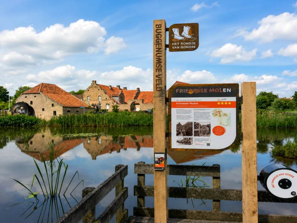Friedesse Molen in het Buggenumse Veld, met informatiebord van Het Rondje van Gondje aan het water.
