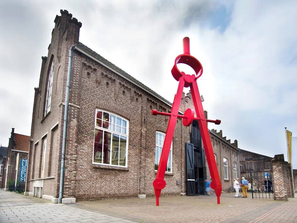 Cuypershuis in Roermond met grote rode passer voor de ingang