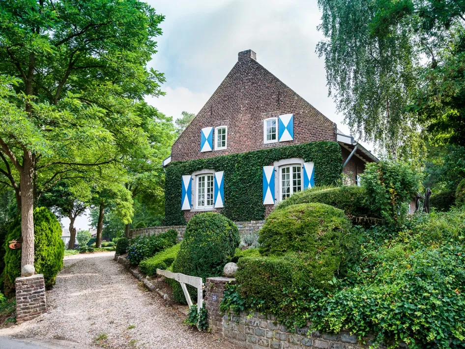 Museum Asselt in een groen omgeven historisch woonhuis met blauw-witte luiken
