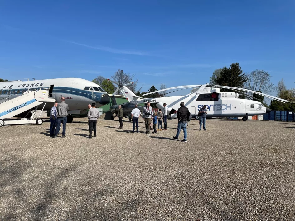 Rondleiding over het terrein van Vliegtuigpark PS Aero tussen een vliegtuig en een helikopter