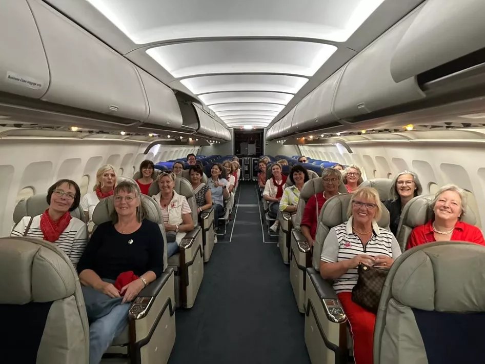 De groep luistert aandachtig in het passagiersruim van het vliegtuig