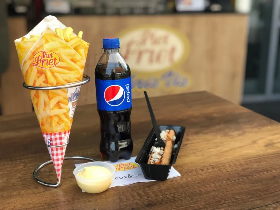 Pommes in der Papiertüte mit Mayonnaise, eine Frikandel Spezial und eine Flasche Pepsi – das gibt es bei Piet Friet im Retailpark Roermond.