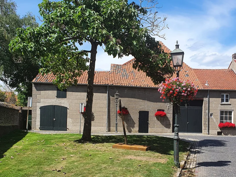 Rustige plek in Wessem met historische gebouwen, groene tuin en rode bloemen aan de gevel
