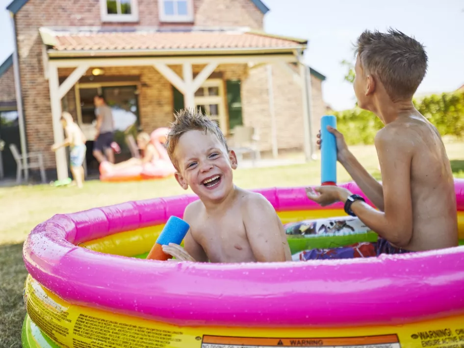 Jongens spelen in het badje voor het vakantiehuis