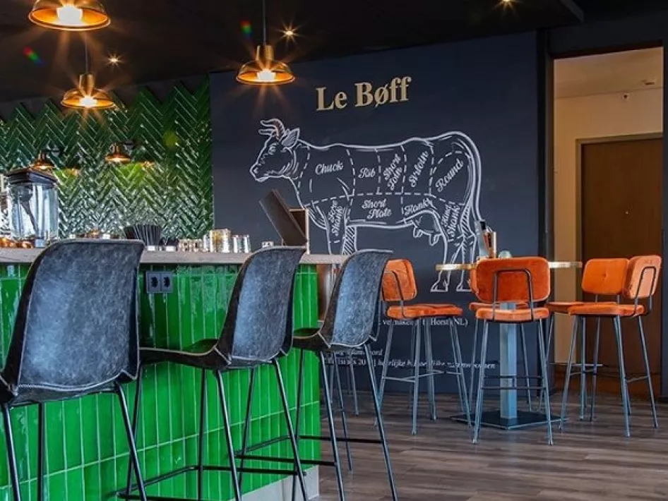 De muurschildering van een koe bij Restaurant BØFF