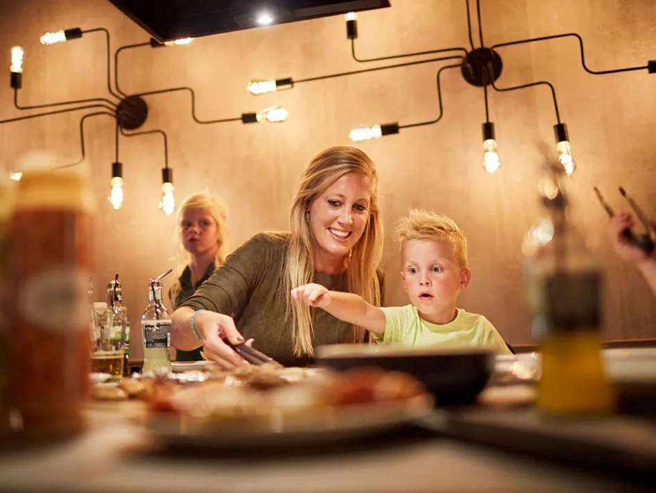 Moeder en zoon genieten samen van het grillen bij Restaurant Grillo in De Leistert.
