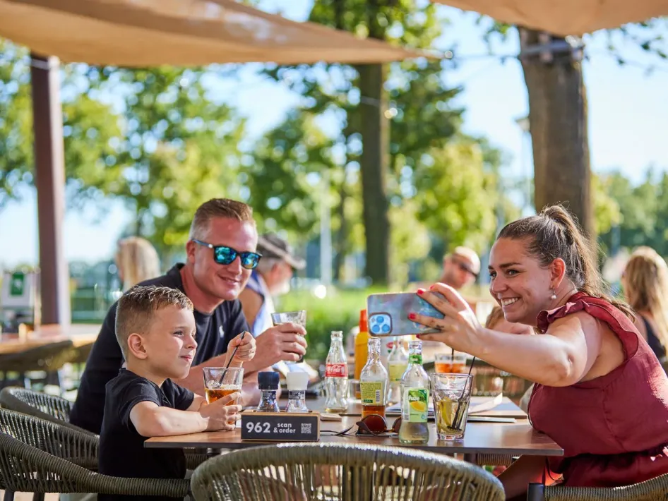 Gezin geniet van een drankje op het terras van Restaurant Grillo bij De Leistert.