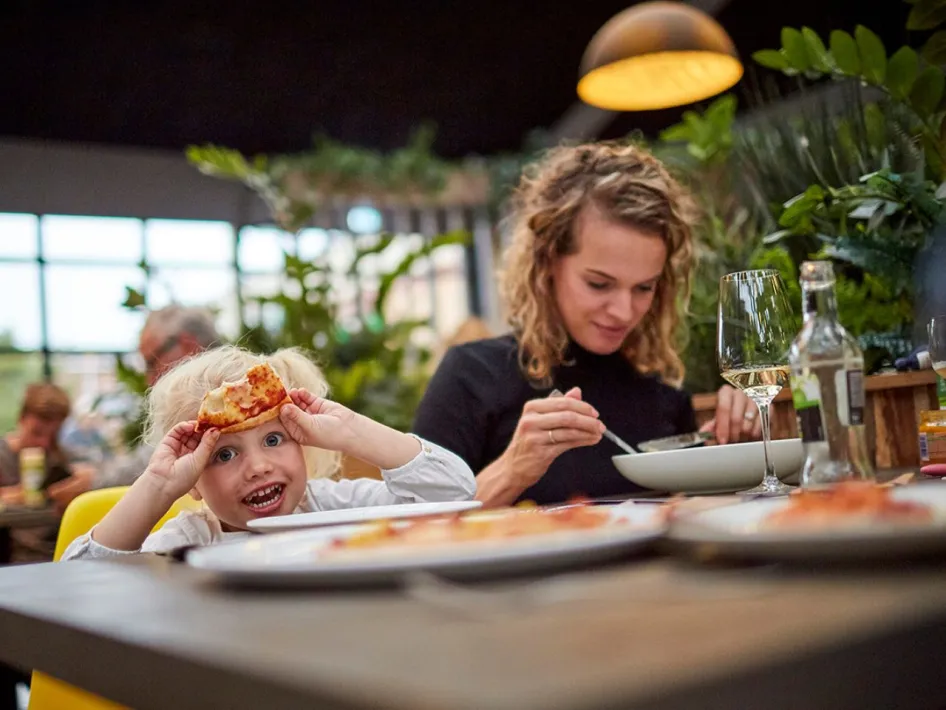 Moeder en kind eten samen pizza in restaurant Via Verde in De Leistert.