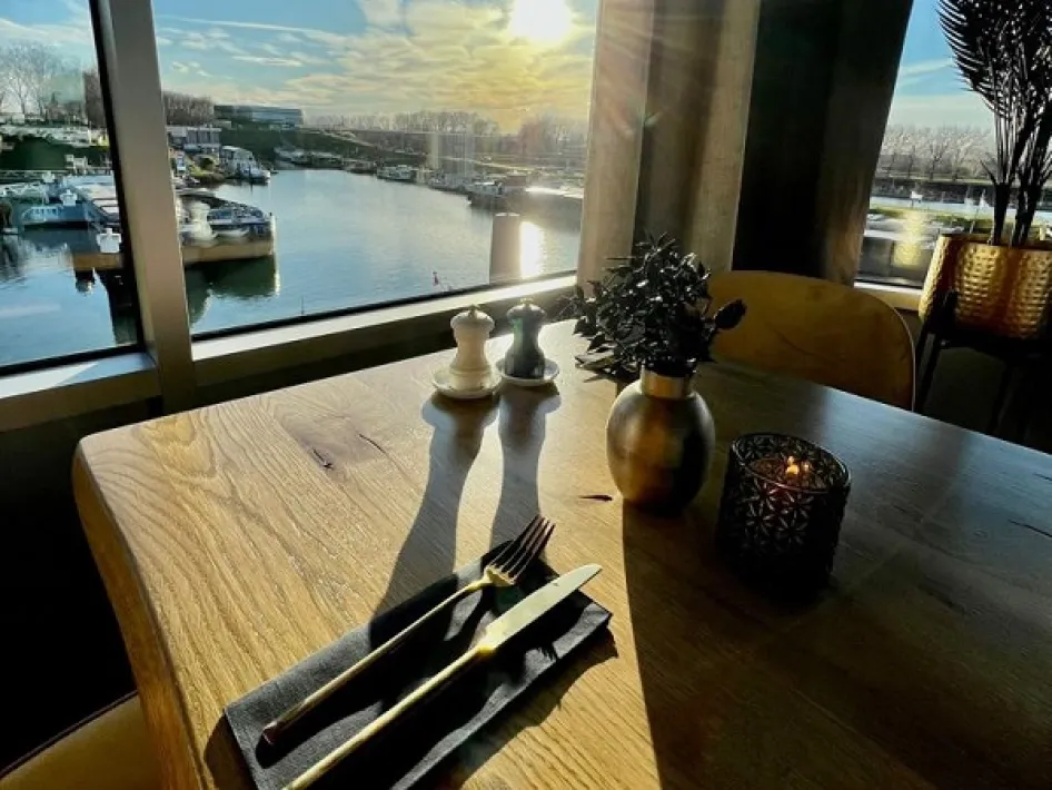 Table by the window with a view of the harbour of Maasbracht