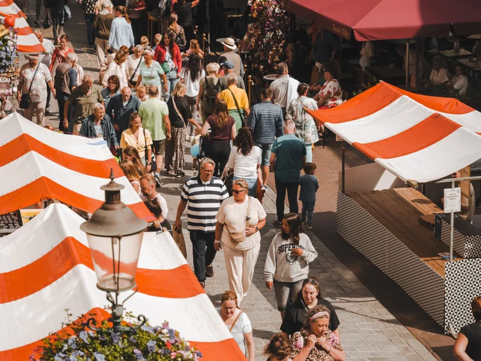 Belebte Einkaufsstraße mit Marktständen und Besuchern während des Sjoemelmert in Roermond.