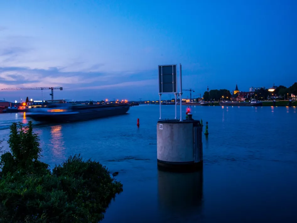 De binnenhaven van Maasbracht met een binnenvaartschip 's avonds