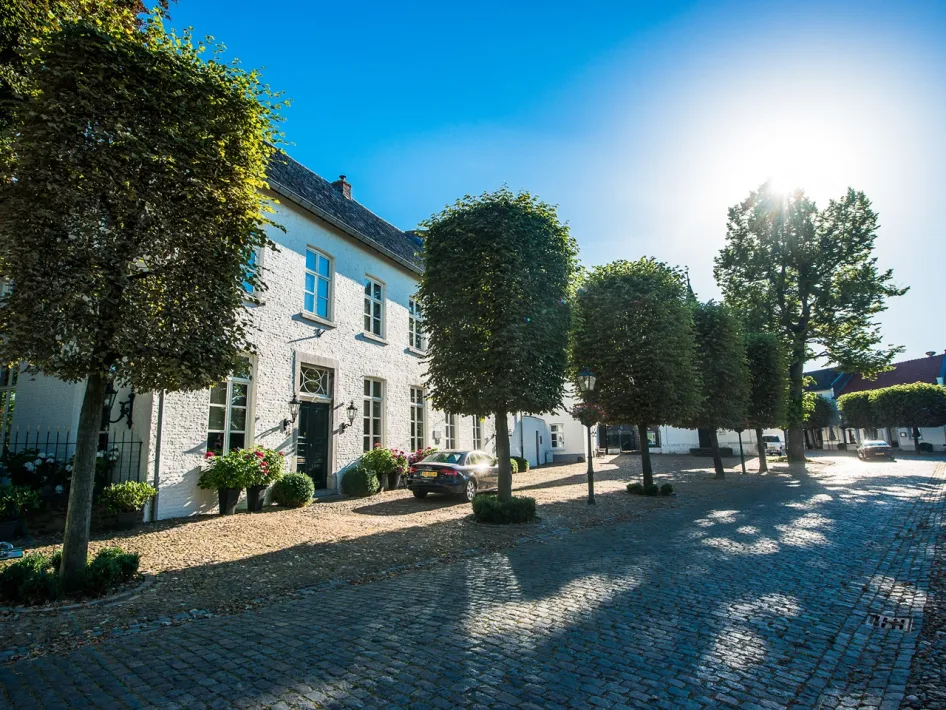 Huizen aan een zonnig plein in Stevensweert tijdens de Stadstour Stevensweert