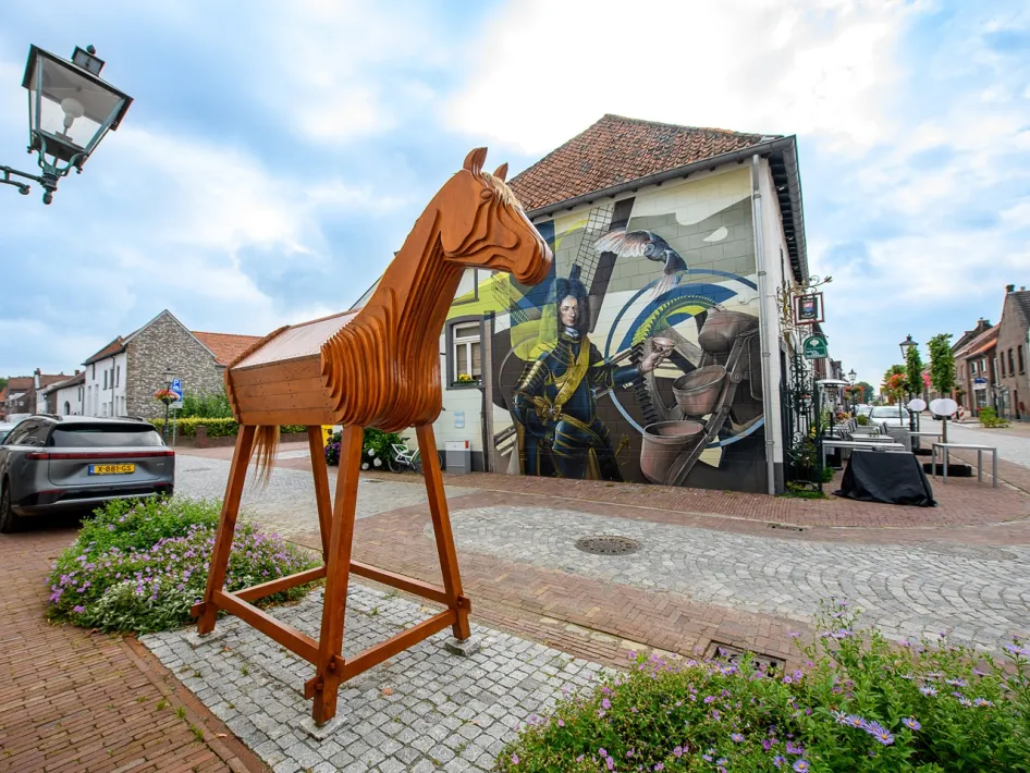 Kunstwerk van een paard en muurschildering in het centrum van Stevensweert