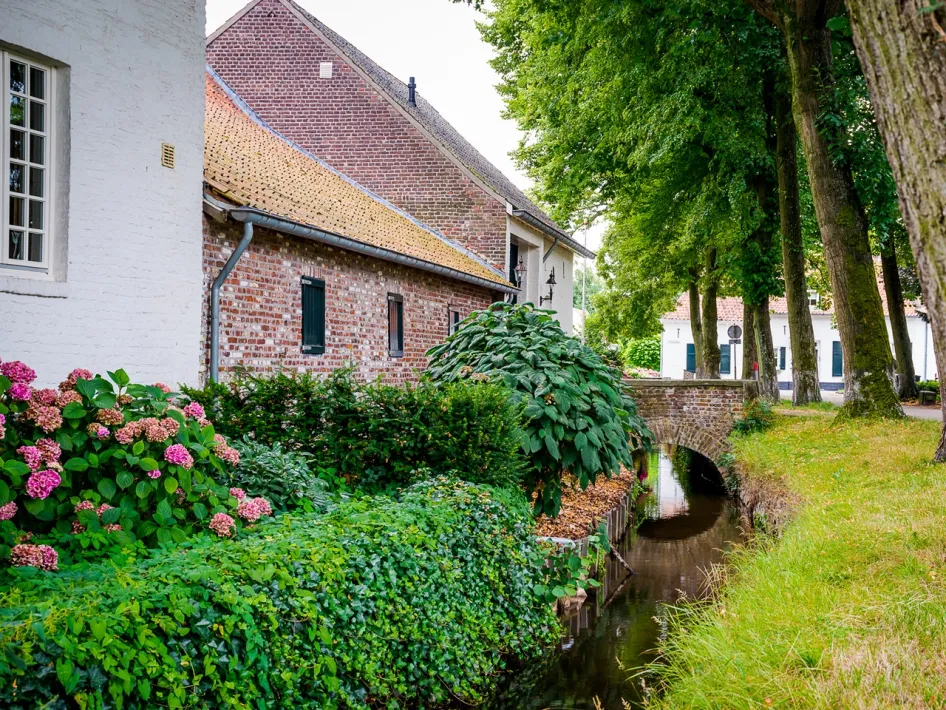 Authentischer Bauernhof mit Ziegelfassade und grünen Akzenten.