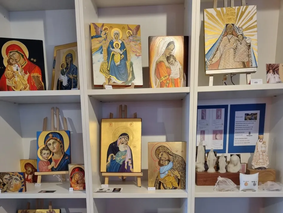 A display cabinet holds paintings, icons and figurines with religious scenes.