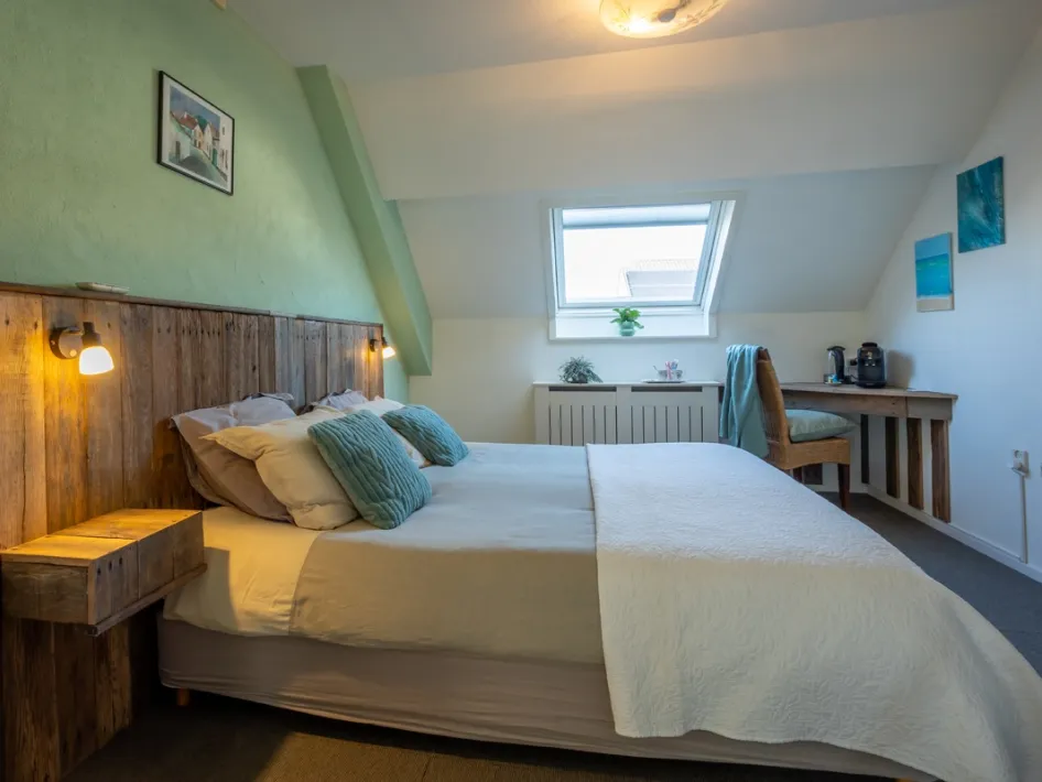 Cozy room at Thorn B&B – A charmingly decorated room with a comfortable double bed, wooden accents, and a soothing touch of green. Ideal for a relaxing stay in historic Thorn.