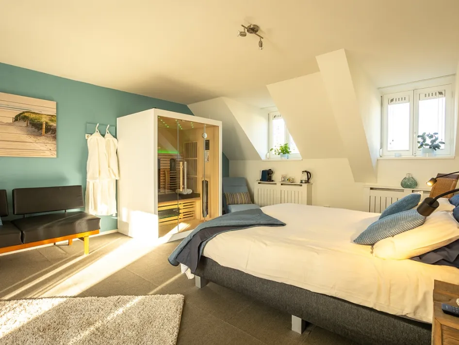 Luxury suite with sauna at Thorn B&B – A spacious and bright room featuring a luxurious double bed, a cozy seating area, and a private infrared sauna. Perfect for a relaxing stay in Thorn.