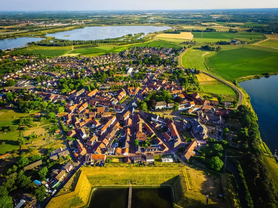 Luchtfoto van Stevensweert met het historische stratenpatroon en de vestingwerken waar je doorheen loopt tijdens de VVV-wandeling Stevensweert, gezien van boven.