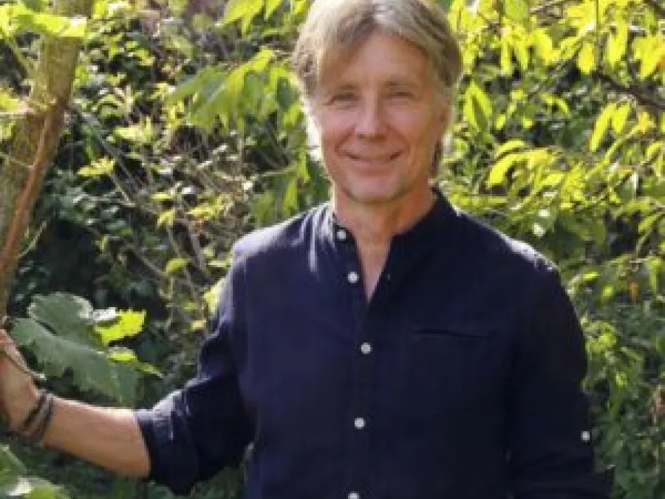 Man staat in het groen en geeft een lezing in een natuurlijke omgeving
