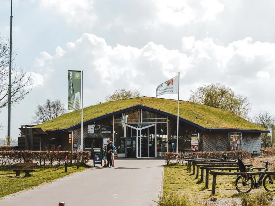 Buitencentrum De Pelen mit einem grünen Dach und Besuchern am Eingang des Nationalparks De Peel.