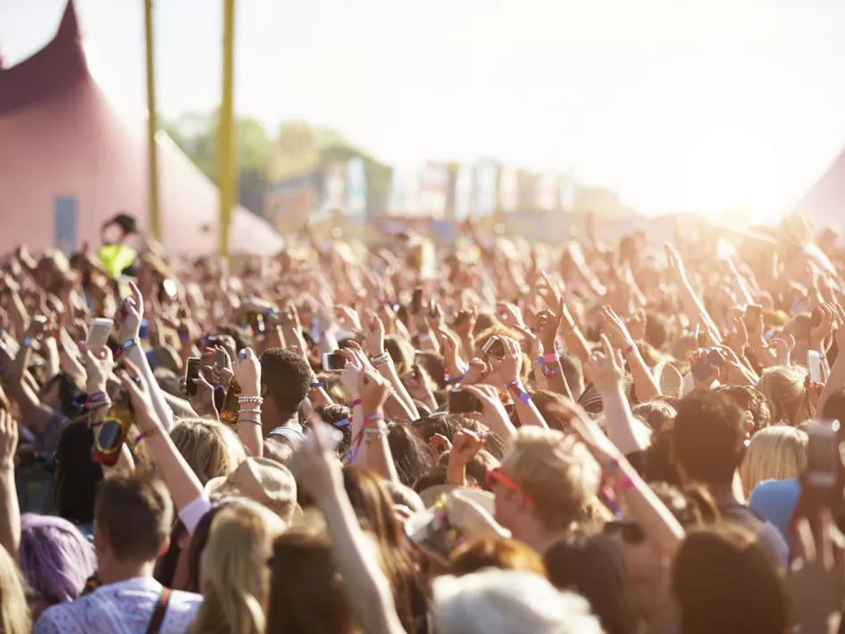 Bezoekers genieten van een optreden tijdens Weerstand Open Air, met handen in de lucht op het zonnige festivalterrein bij de Weerstand in Roermond