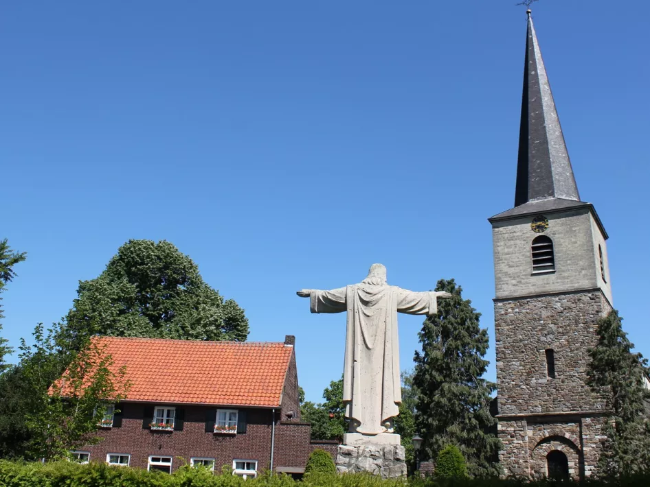 Het stadje Wessem met de kerk en het standbeeld op het plein die je tijdens de VVV wandeling Wessem ook aan zal doen
