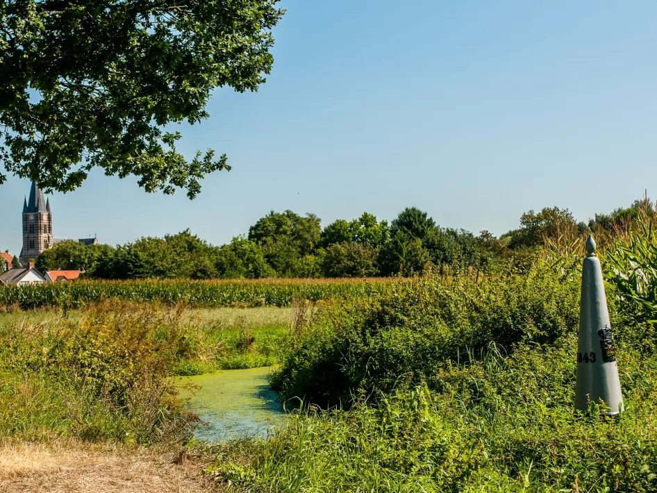 Grenspaal in de natuur met op de achtergrond Thorn