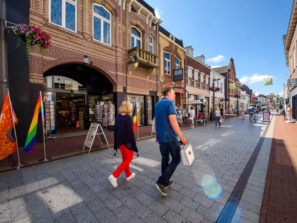 Man and woman walk through downtown Weert with shopping bags