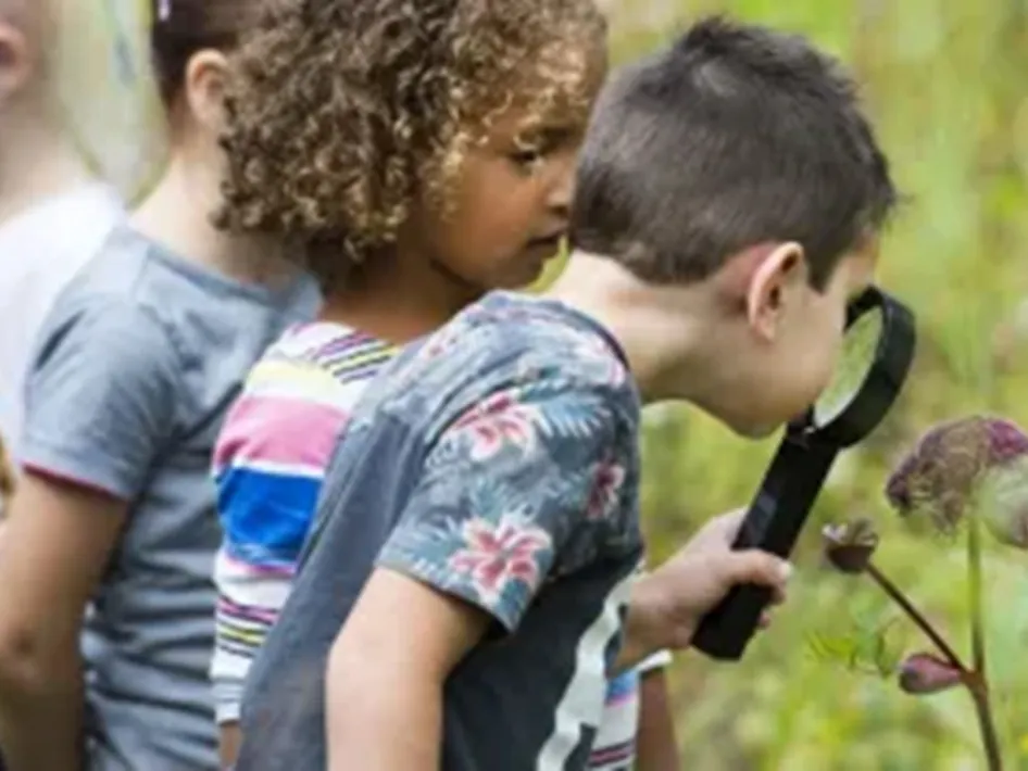 Sfeerbeeld kinderen met vergrootglas tijdens de Zomerexpeditie.