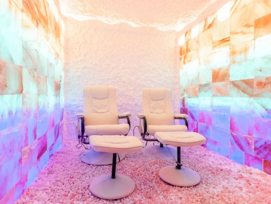 Two relaxation chairs in an atmospheric salt room with salt stone walls and soft lighting at Zout & Zo.