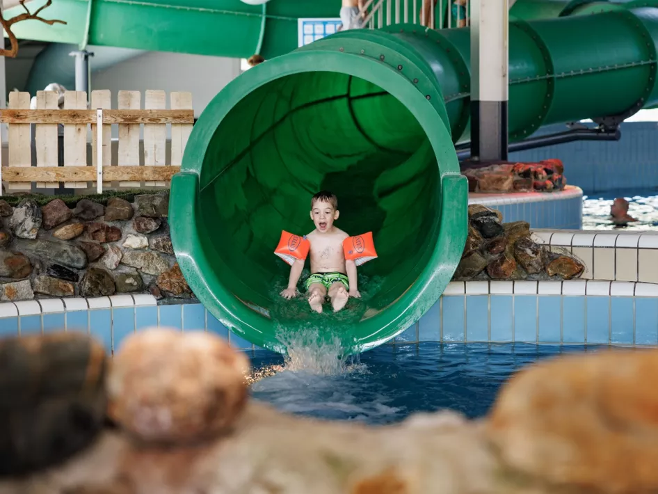 Boy slides down giant slide at Weerterbergen Swimming Pool