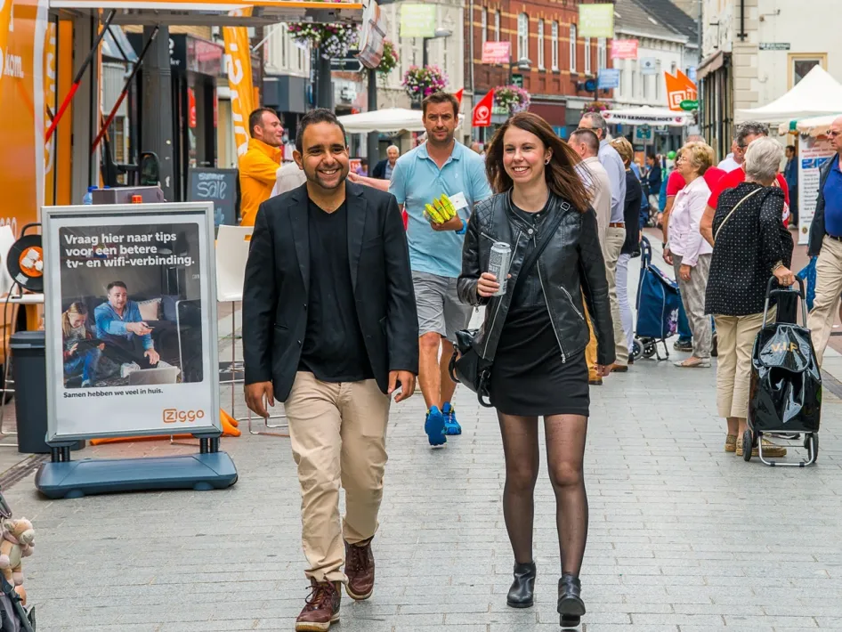 2 mensen die wandelen door de braderie in de binnenstad van weert.