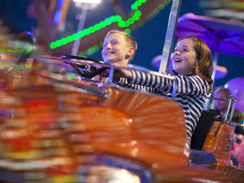 ai afbeelding van jonge en meisje op kermis in linne die in een attractie zitten