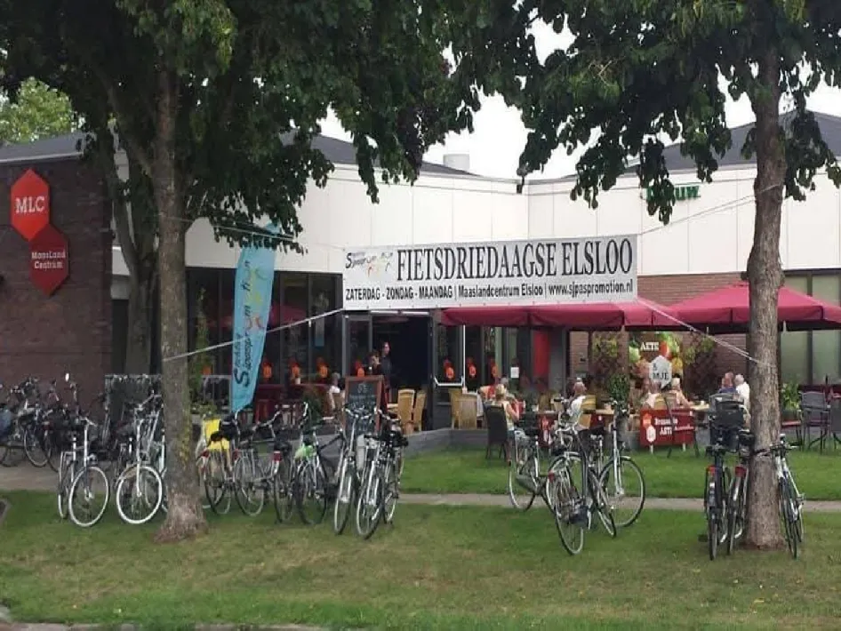 fietsdriedaagse in elsloo met een spandoek opgehangen voor het gebouw en het is gebonden aan 2 bomen.