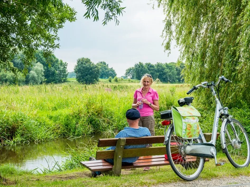 Radfahrer machen eine Pause am Bach