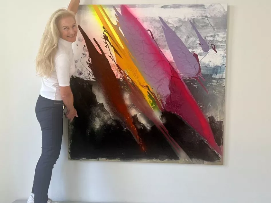 Mathilde Pil voor haar schilderij, titel: help mama de wereld staat in brand.