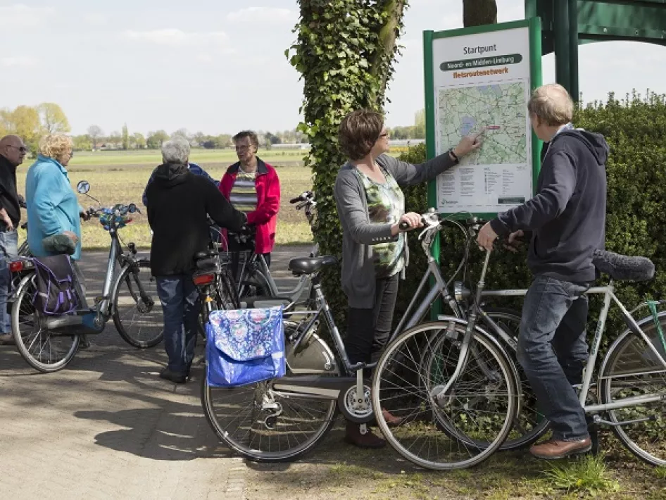 Fietsers kijken op een fietsknooppuntenbord