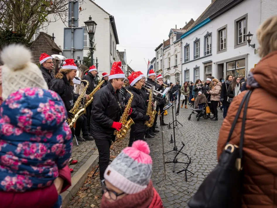 Muzikanten met kerstmutsen spelen voor bezoekers tijdens de Kerstmarkt Thorn.