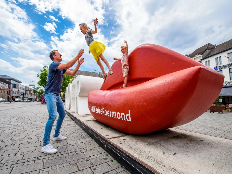 Kind springt bij vader in de armen met kinder zomerfestival