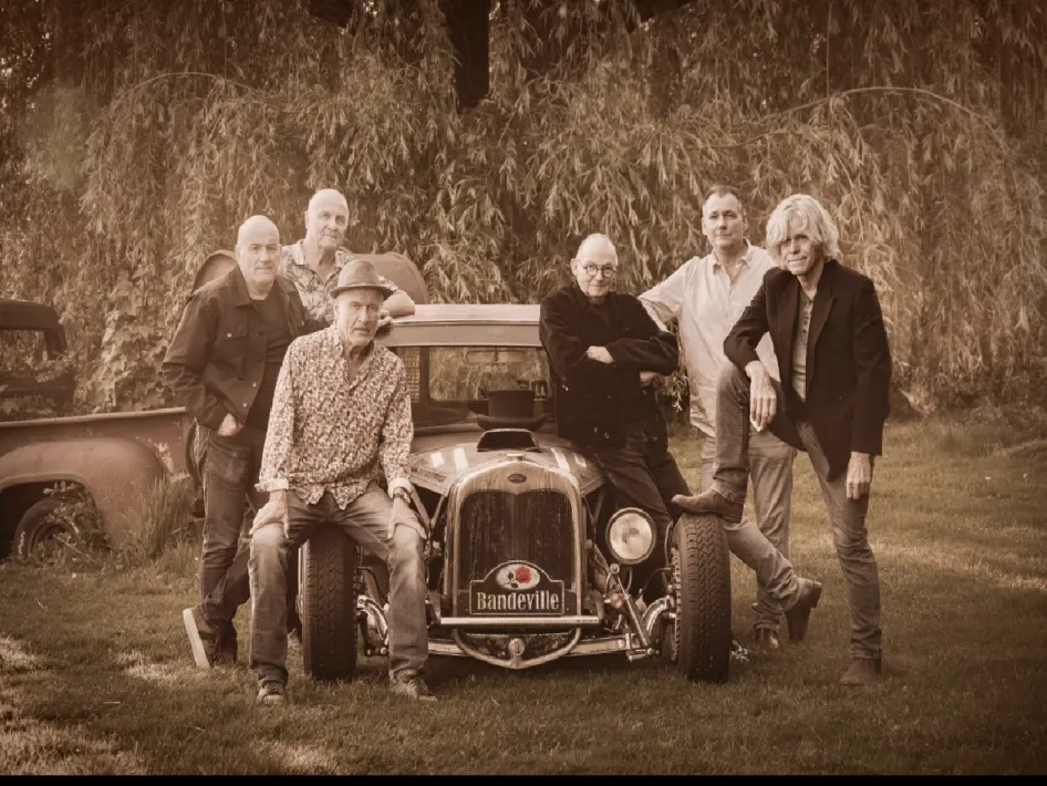 foto van de leden die het evenement love and emotion concert gaan doen, 6 mensen die leunen tegen een oldtimer